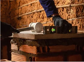 Pedreiro(a) construindo e medindo