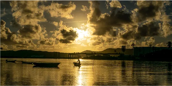 Canoas de pesca em um mar calmo ao por do sol